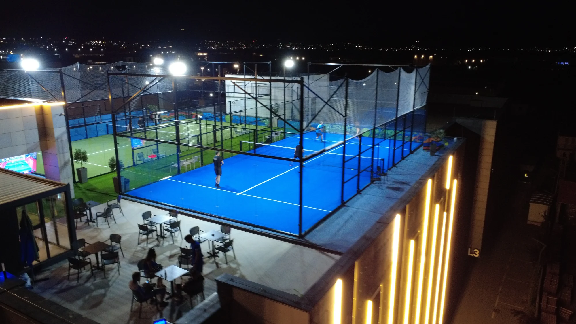 Sky Padel rooftop courts and guests at night