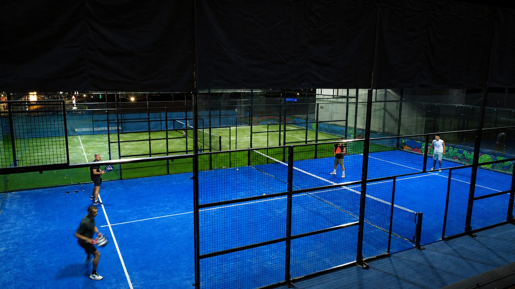 A doubles padel match on the blue rooftop court