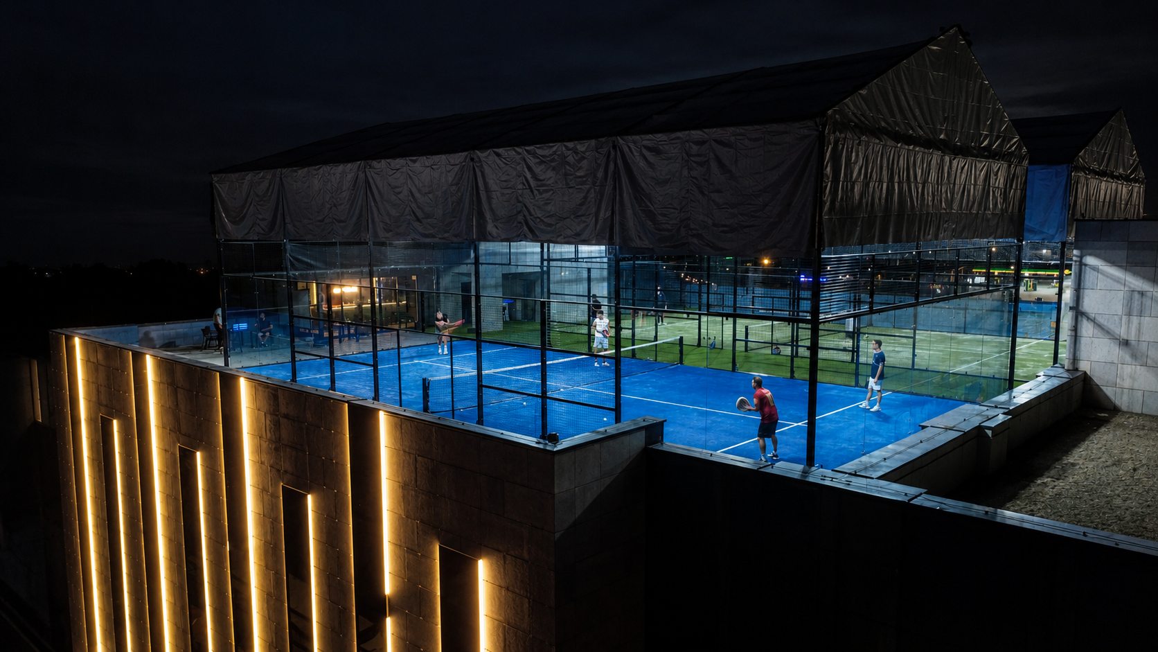 Players on both Sky Padel rooftop courts at night